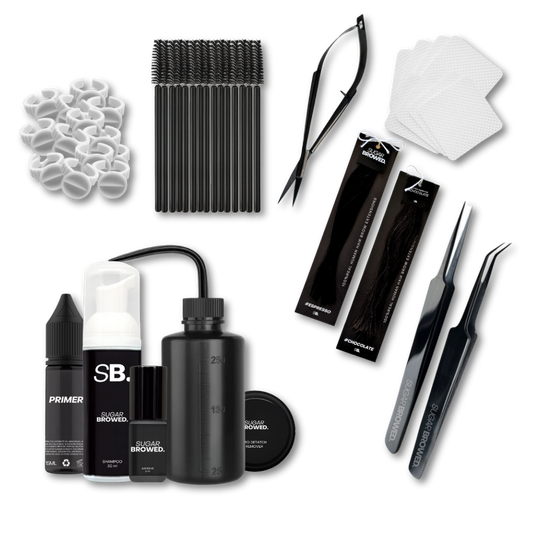 Complete brow extension starter kit beautifully arranged in a branded box, featuring professional tools including isolation and placement tweezers, water bottle, adhesive, brushes, cleansing brush, brow shampoo, brow extensions in two shades, wipes, and glue rings, ideal for beginner and advanced stylists.
