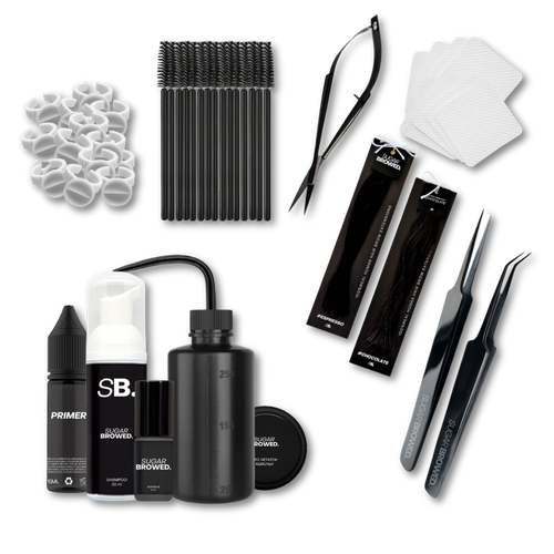 Complete brow extension starter kit beautifully arranged in a branded box, featuring professional tools including isolation and placement tweezers, water bottle, adhesive, brushes, cleansing brush, brow shampoo, brow extensions in two shades, wipes, and glue rings, ideal for beginner and advanced stylists.